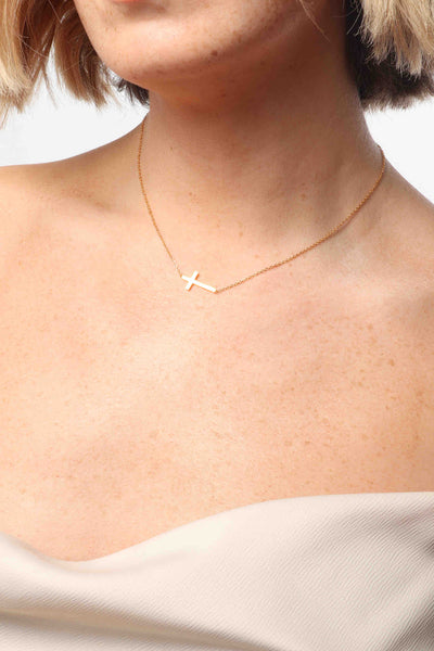 Marrin Costello wearing Marrin Costello Jewelry Barry Necklace sideways cross necklace with lobster clasp closure and extender. Waterproof, sustainable, hypoallergenic. 14k gold plated stainless steel.