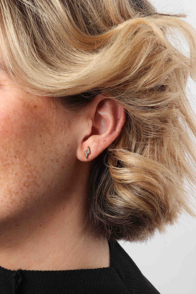 Marrin Costello wearing Marrin Costello Jewelry Bolt Studs lightning bolt CZ post back earrings — for pierced ears. Waterproof, sustainable, hypoallergenic. 14k gold plated stainless steel.