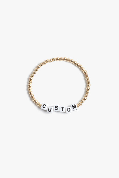 Marin Costello Jewelry Crown Letter Bracelet beaded block letter bracelet, customizable. White block letters, gold beads. Waterproof, sustainable, hypoallergenic. 14k gold plated stainless steel.