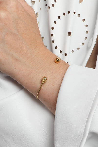 Marrin Costello wearing Marrin Costello Jewelry Hyde Cuff skull adjustable bracelet with cuff bracelet opening. Waterproof, sustainable, hypoallergenic. 14k gold plated stainless steel.