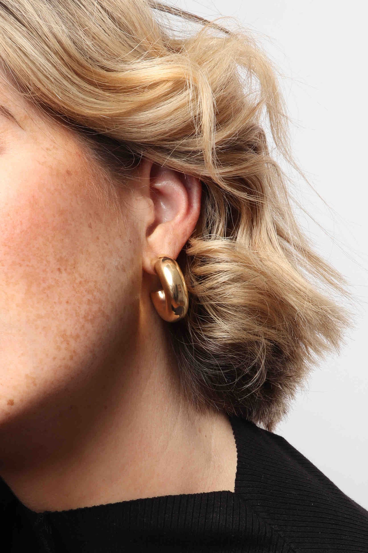 Marrin Costello wearing Marrin Costello Jewelry Monterey Hoops thick chunky hollow tube post back earrings — for pierced ears. Waterproof, sustainable, hypoallergenic. 14k gold plated stainless steel.
