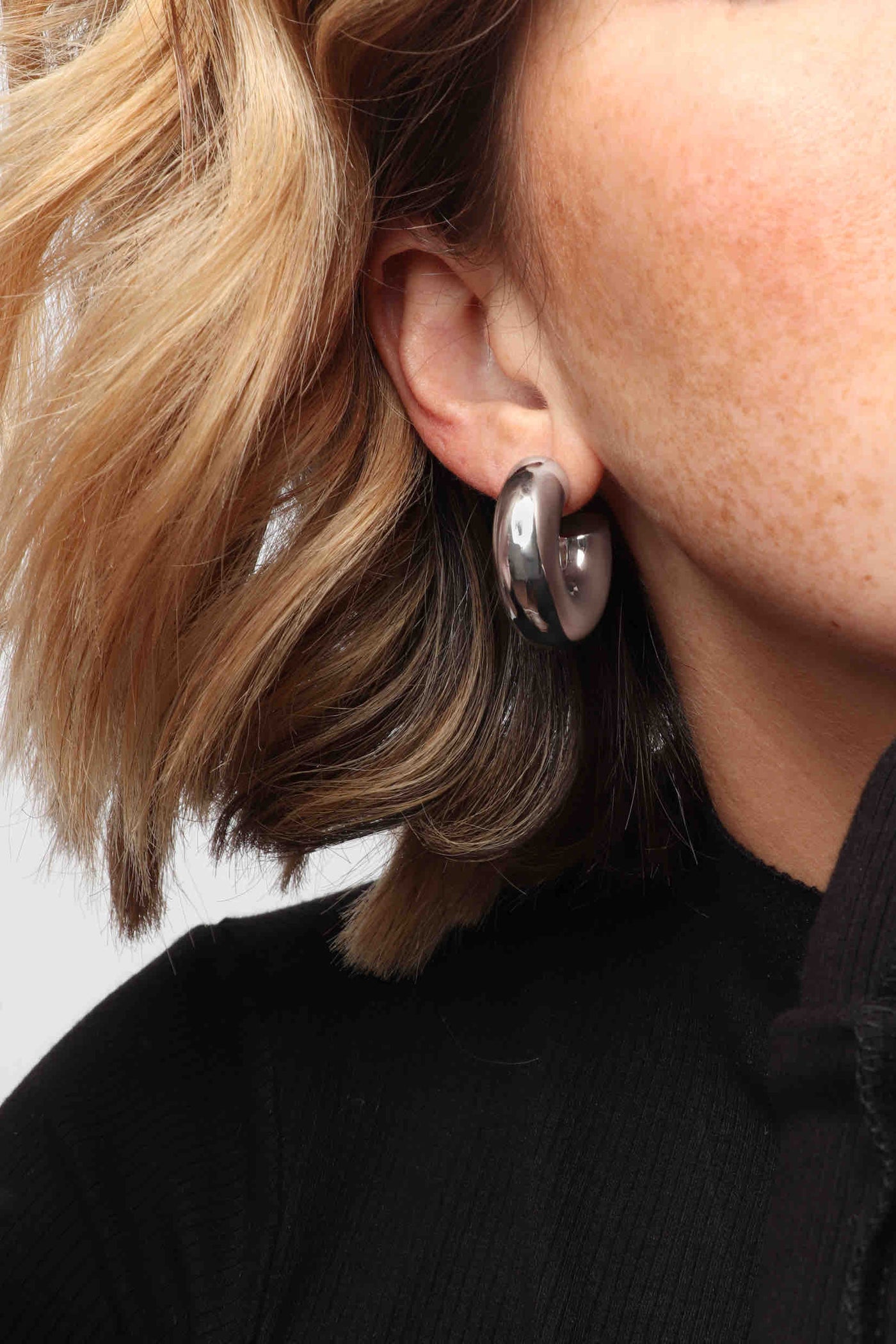 Marrin Costello wearing Marrin Costello Jewelry Monterey Hoops thick chunky hollow tube post back earrings — for pierced ears. Waterproof, sustainable, hypoallergenic. Polished stainless steel.