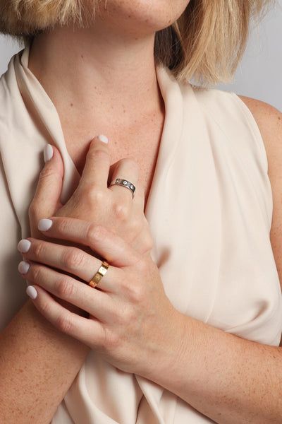 Marrin Costello wearing Marrin Costello Jewelry Orion Band star motif ring with CZ detail. Available in sizes 6, 7, 8. Waterproof, sustainable, hypoallergenic. 14k gold plated and polished stainless steel.