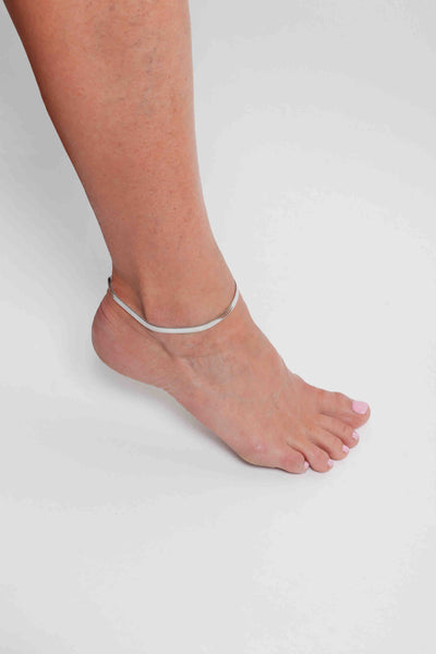 Marrin Costello wearing Marrin Costello Jewelry 5mm thick herringbone snake chain anklet with lobster clasp closure. Waterproof, sustainable, hypoallergenic. Polished stainless steel.